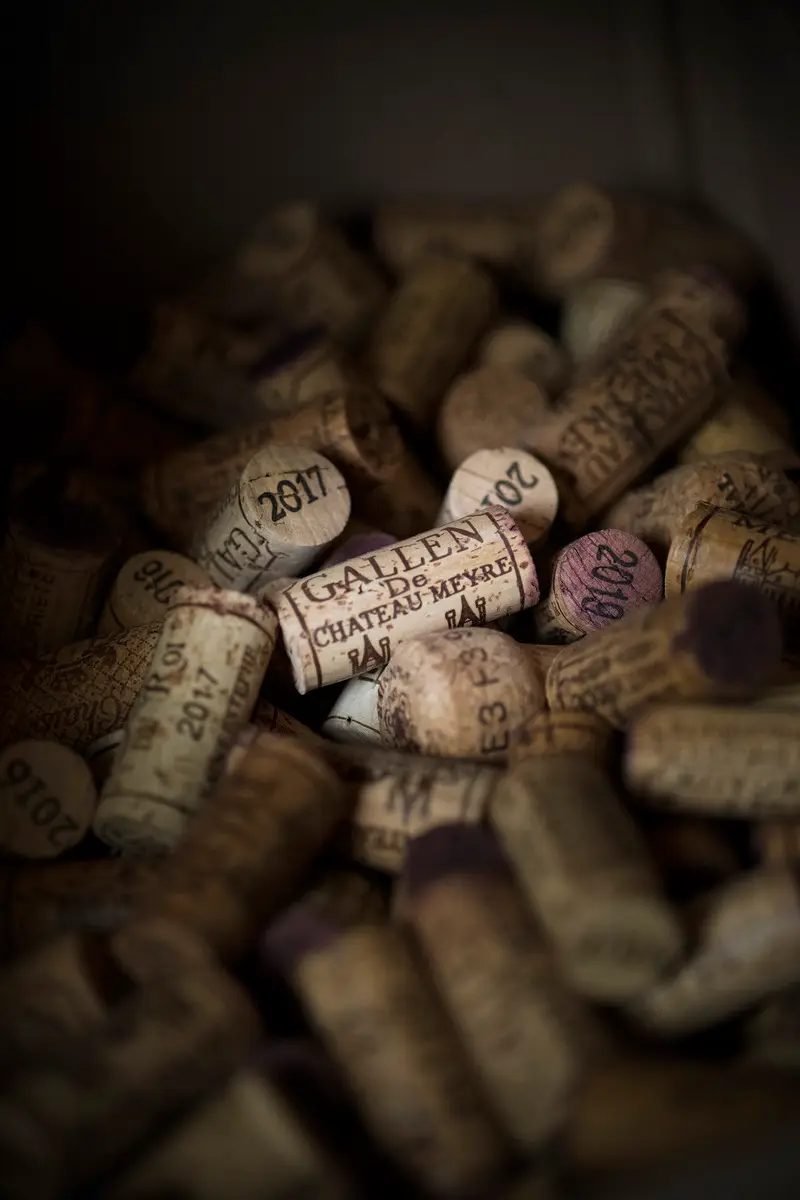 Corks stamped Château Meyre set in front of bottles of wine.