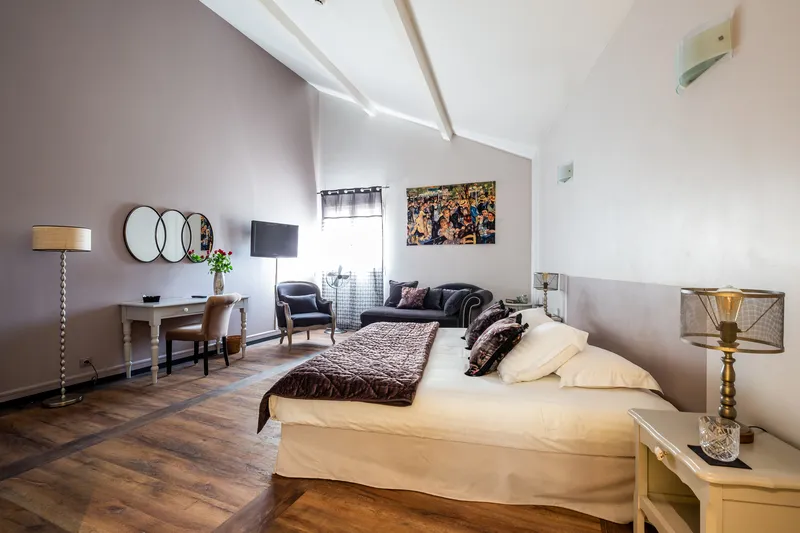 Spacious room with a double bed, a desk and a sitting area at Le Clos de Meyre.