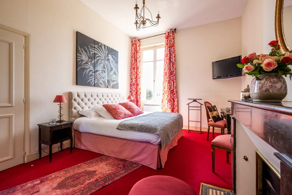 Lit double et moquette rouge dans la chambre Vinalia du Clos de Meyre à Avensan.