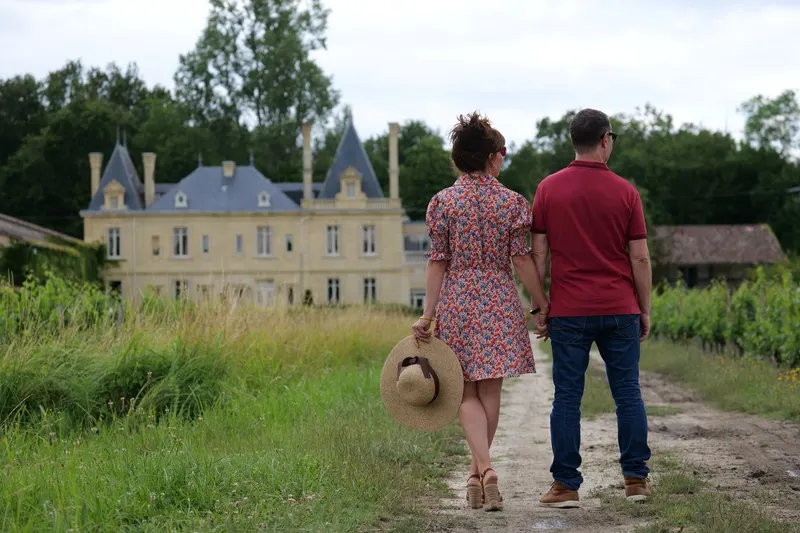 Couple sur un chemin entre les vignes face au Château Meyre à Avensan.