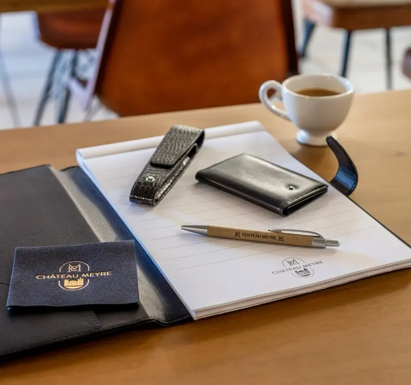 Carnet et matériel de séminaire Château Meyre disposés sur une table de réunion.