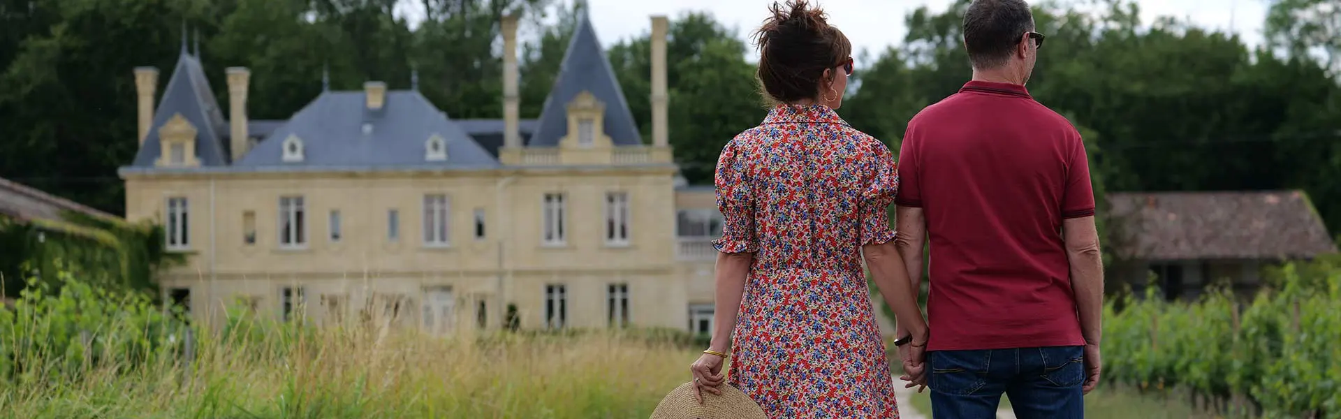 Couple walking between the vines in front of Château Meyre in Avensan.